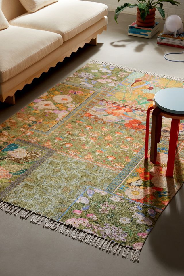 a living room with a large rug on the floor and a couch in the background