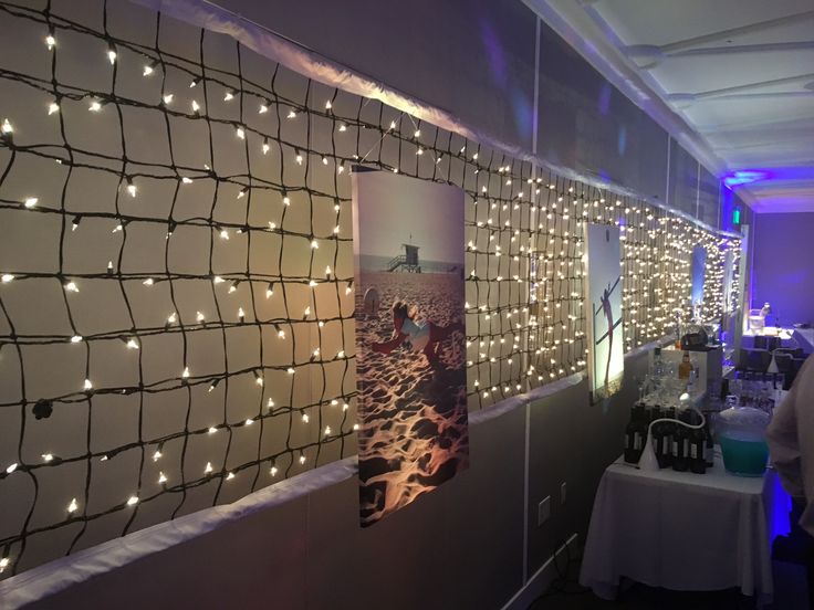 people are standing in front of a wall decorated with lights and pictures on the walls