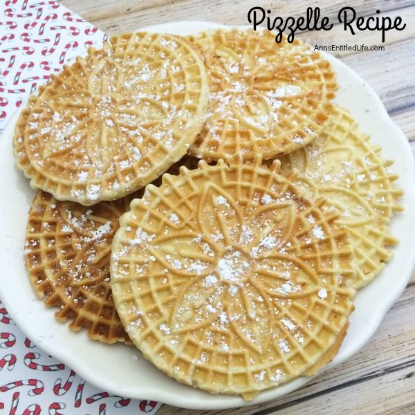 three waffles on a white plate covered in powdered sugar and sprinkled with icing