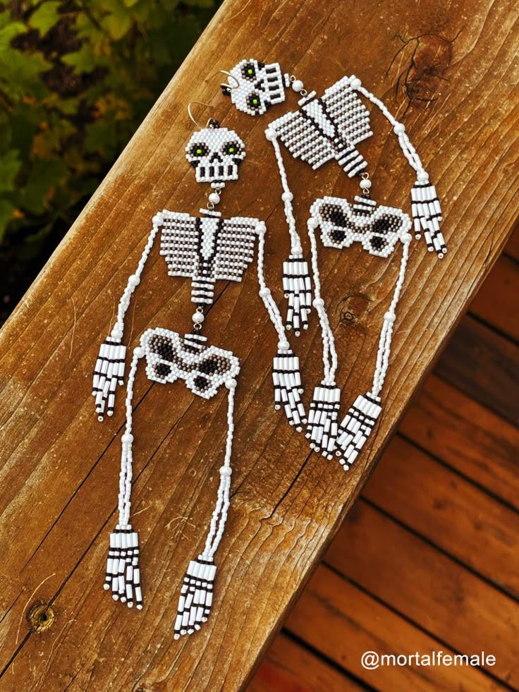 three skeleton string art pieces on a wooden surface