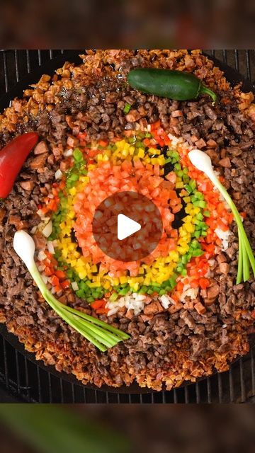 a grill with food on it that looks like an eyeball in the middle and vegetables around it