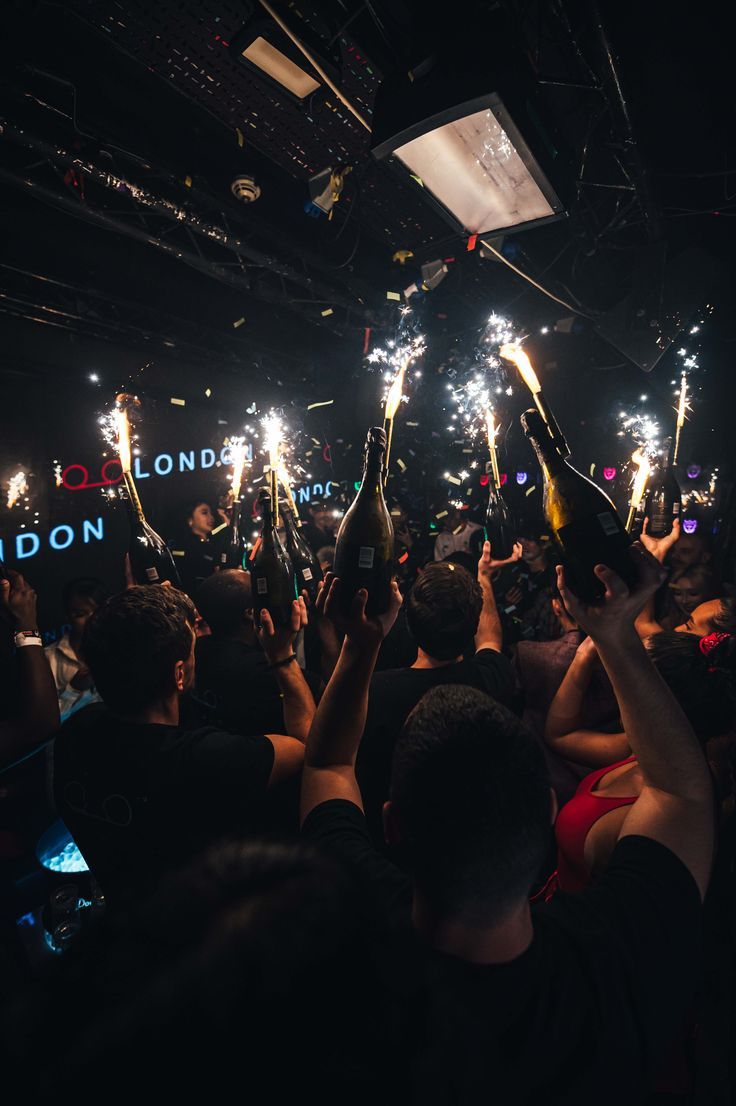 people holding sparklers in the air at a concert