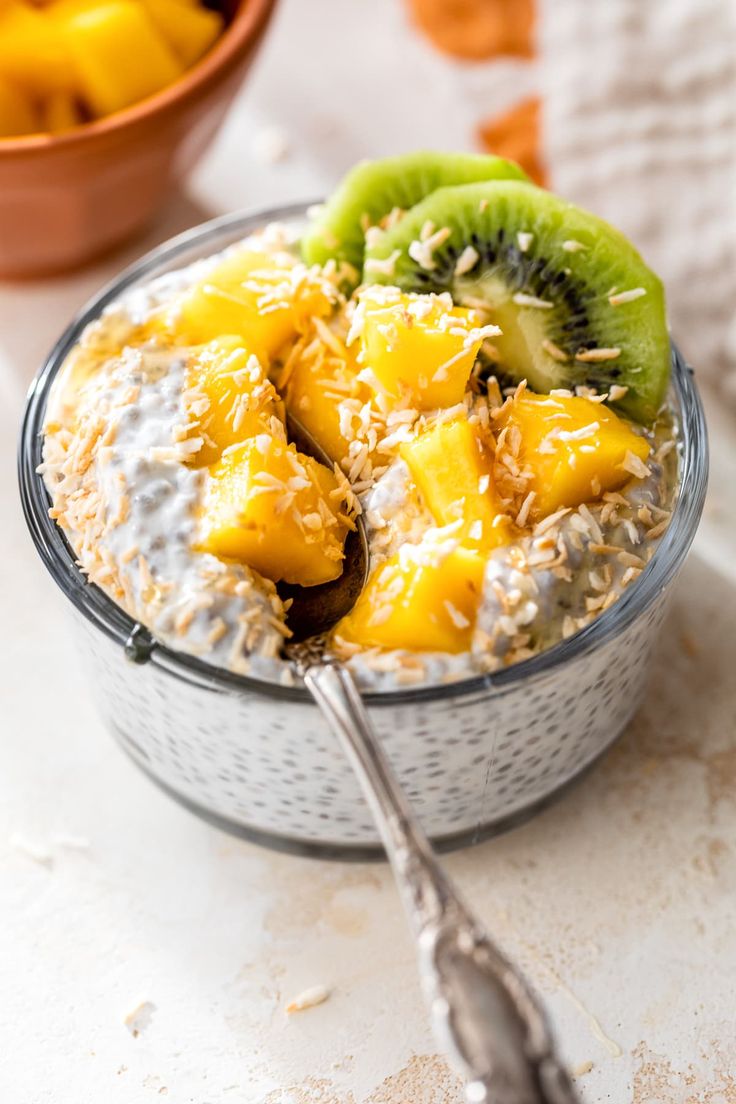 a bowl filled with oatmeal topped with kiwis and sliced bananas