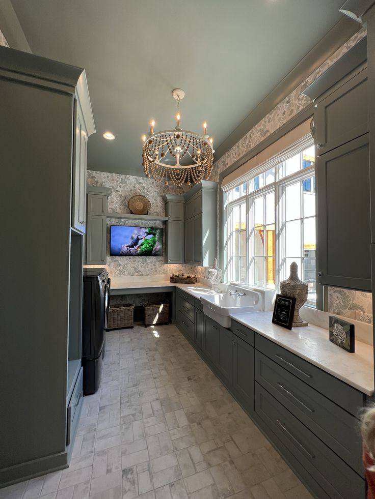 a kitchen with gray cabinets and a chandelier