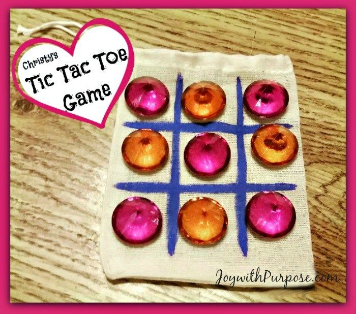 some pink donuts sitting on top of a cloth bag with a tic - tac toe game