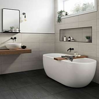 a white bath tub sitting in a bathroom next to a sink under a large mirror