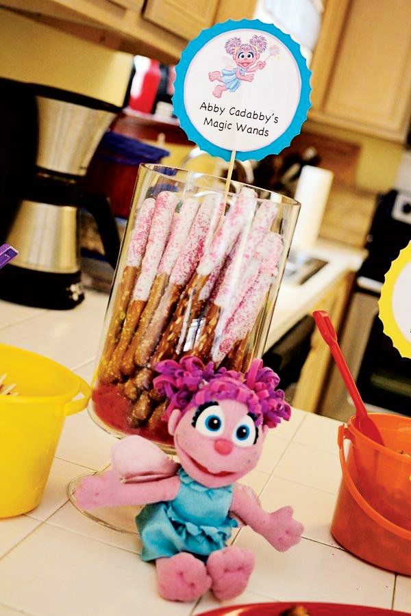 an assortment of candy sticks and candies in a glass container on a kitchen counter