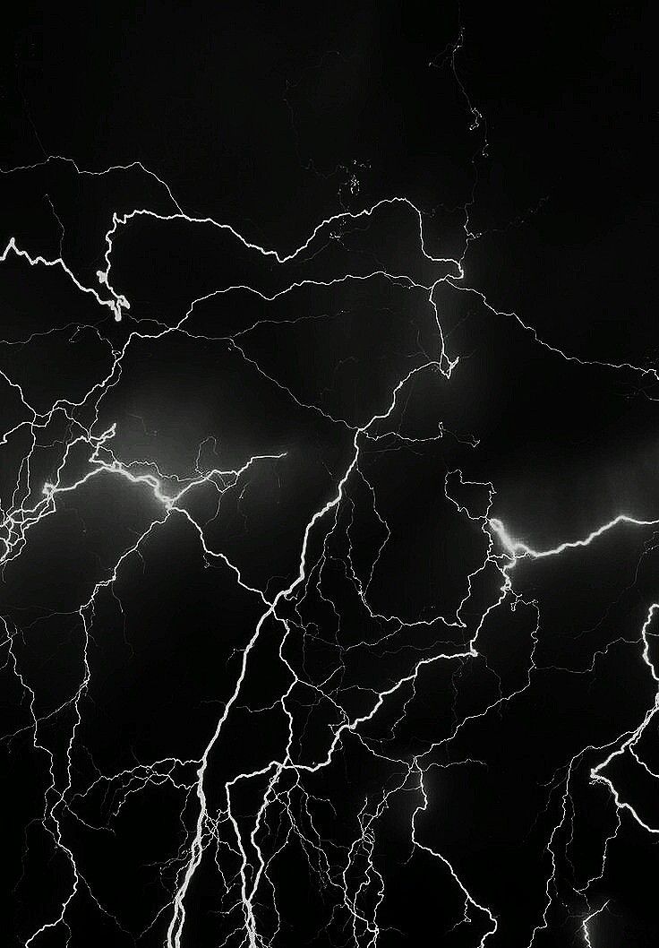 a black and white photo of lightning in the night sky