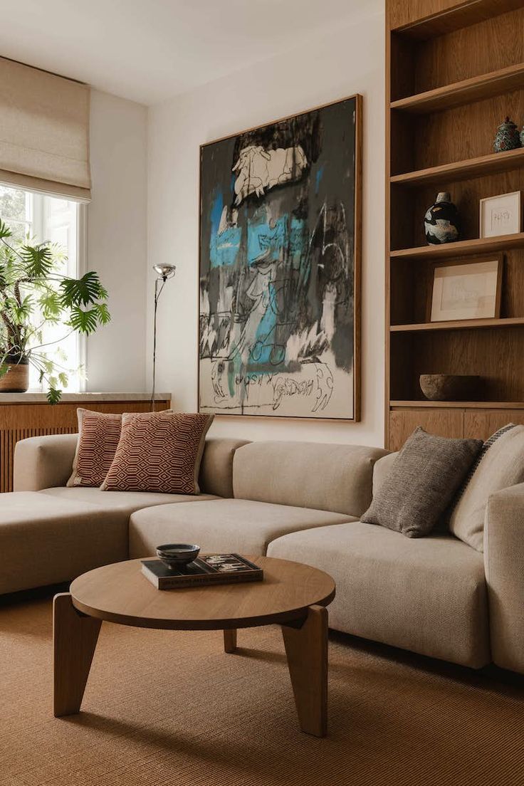 a living room with a couch, coffee table and bookshelf on the wall