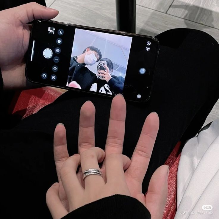 a person taking a photo with their cell phone while sitting on the floor in front of them