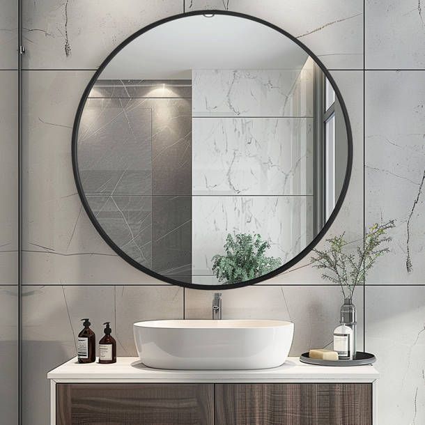 a round mirror hangs above a sink in a bathroom with marble tiles on the walls