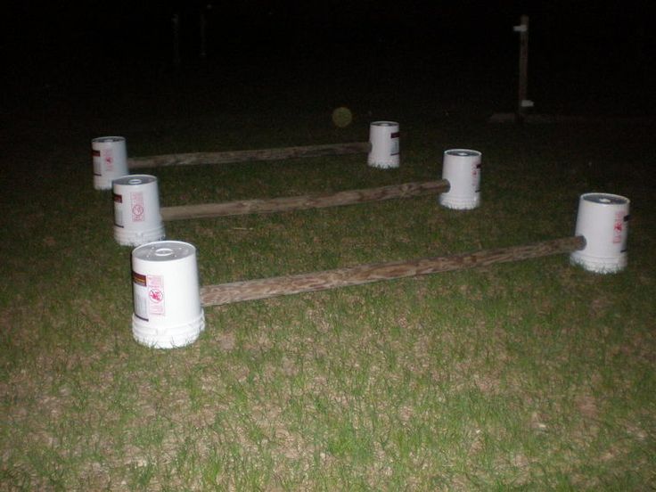 several buckets sitting on top of grass near each other in the middle of a field