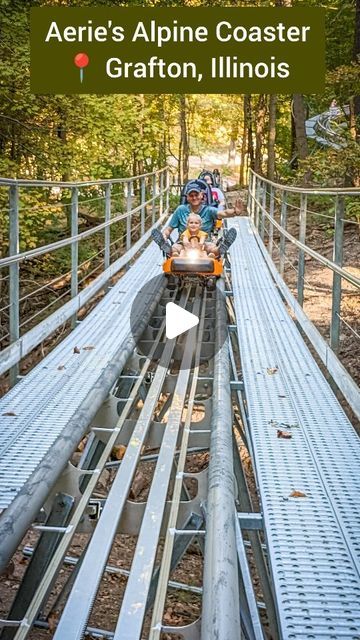 the roller coaster is going down the hill in the park with people riding on it