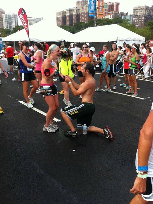 a group of people running in a race with no shirts on and one person holding his leg up