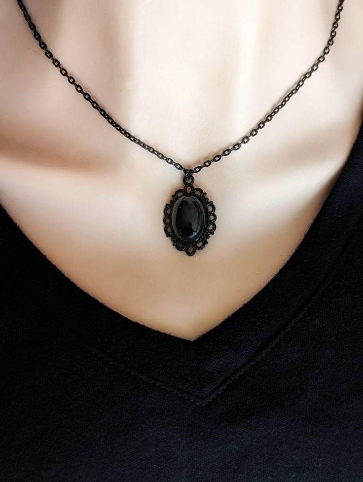 "This Obsidian necklace features a richly polished black Obsidian cabochon set in an elegant oval pendant. The vintage-inspired pendant has a lovely lace-like design around the perimeter. The combination of the pendant and inky black stone is beautiful. Available in three finishes: silver, bronze, or black. All pendants are plated brass. Chains are plated brass except for the silver version which is stainless steel.  For those that follow Crystal beliefs: Obsidian is believed to be truth-enhanci Black Stone Necklace, Black Obsidian Necklace, Obsidian Necklace, Victorian Pendants, Necklace Gothic, Vintage Inspired Jewelry, Witchy Jewelry, Crystal Necklaces, Jewelry Black