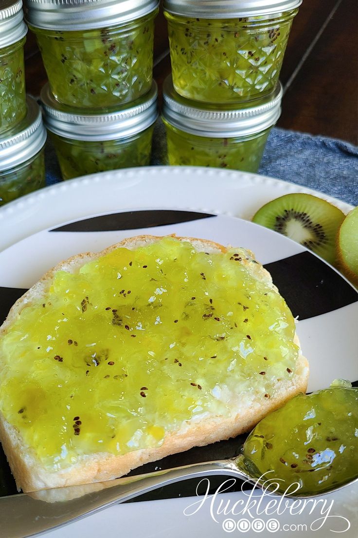 a piece of bread on a plate with pickles next to it and jars in the background