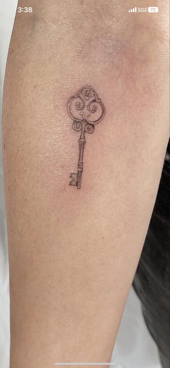 a small key tattoo on the right thigh, with an eyeball in the middle