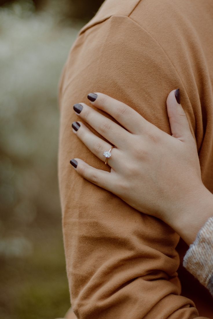 a close up of a person's hand on the shoulder of another persons arm