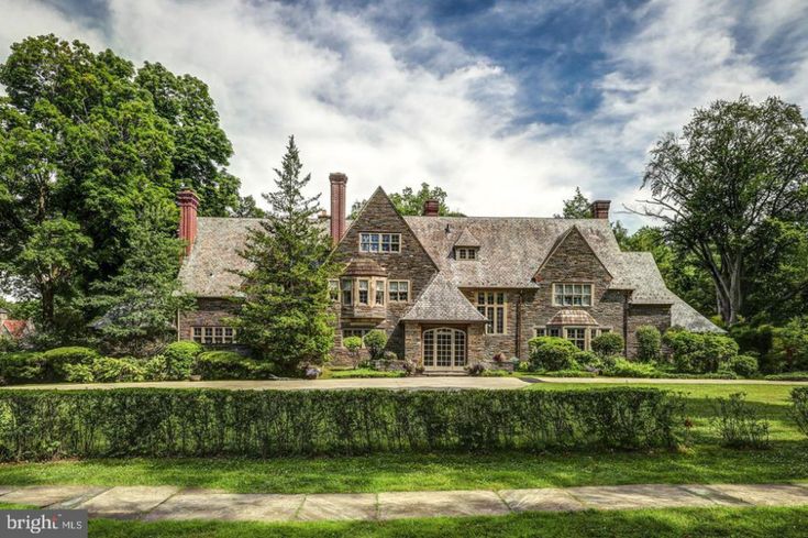 a large brick house surrounded by lush green trees