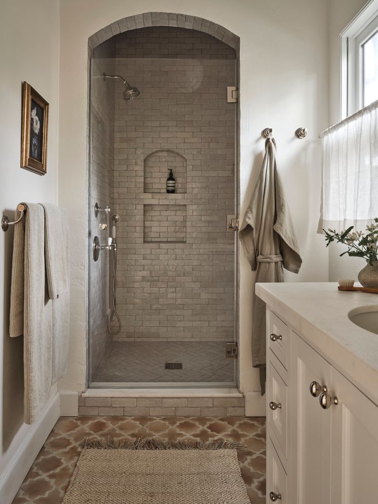 a bathroom with a walk in shower next to a sink