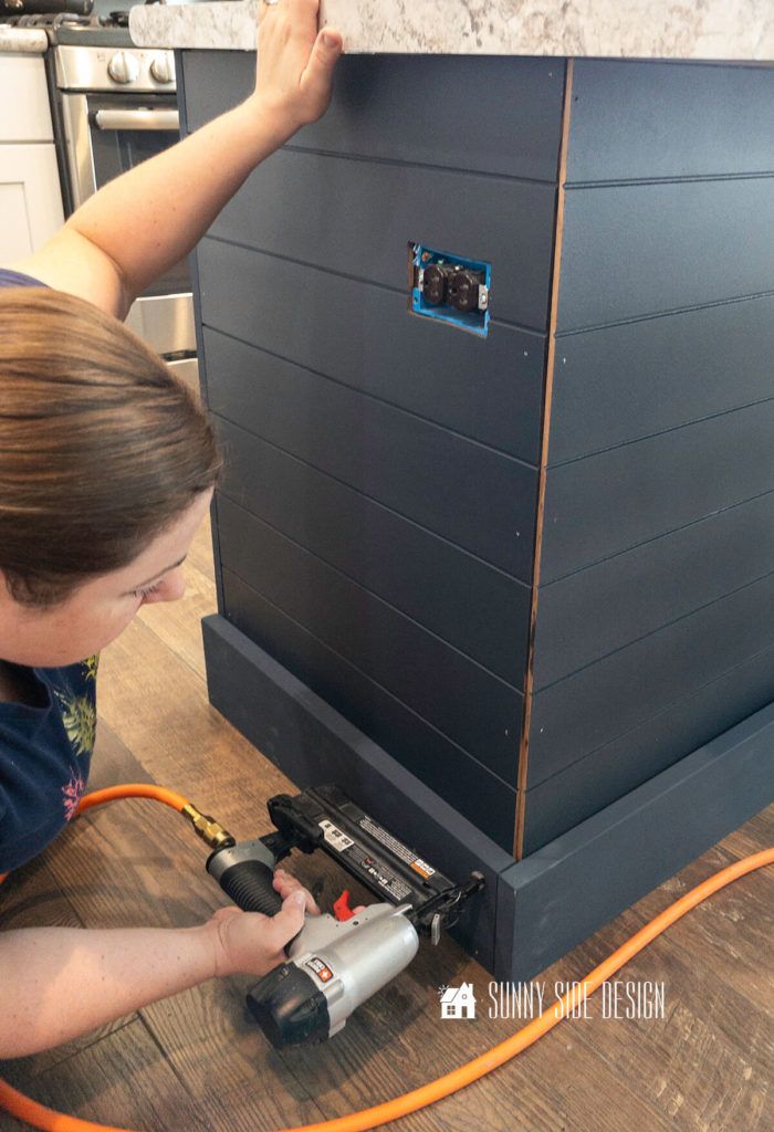 a woman is working on a piece of furniture with an electric drill and power tool