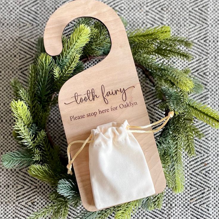 a wooden bag with a drawstring on it sitting next to some pine branches