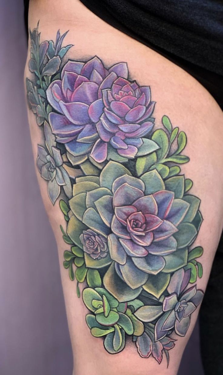 a woman's thigh with succulents and leaves tattoo on it,