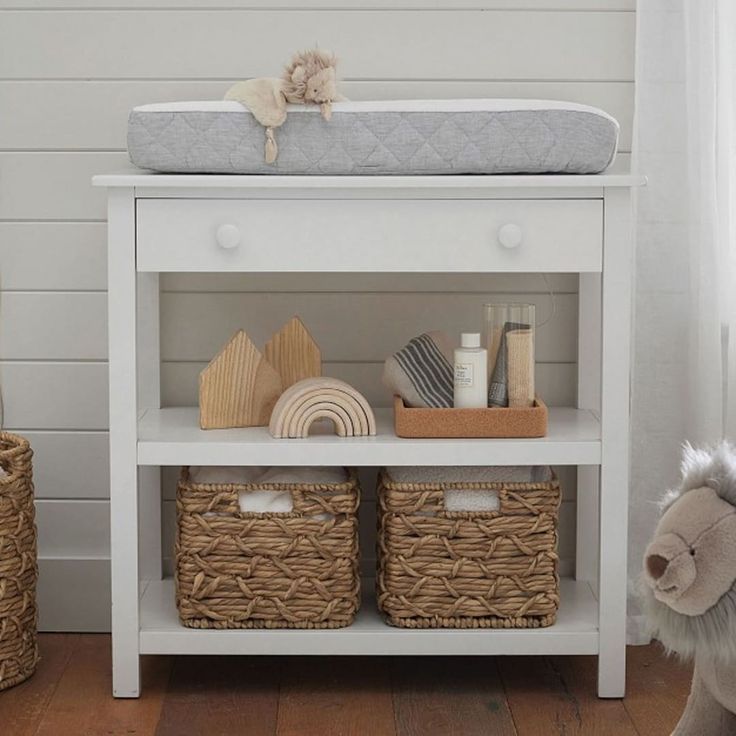 a white shelf with baskets and toys on it