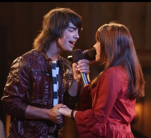 a man and woman standing next to each other while holding microphones in their hands