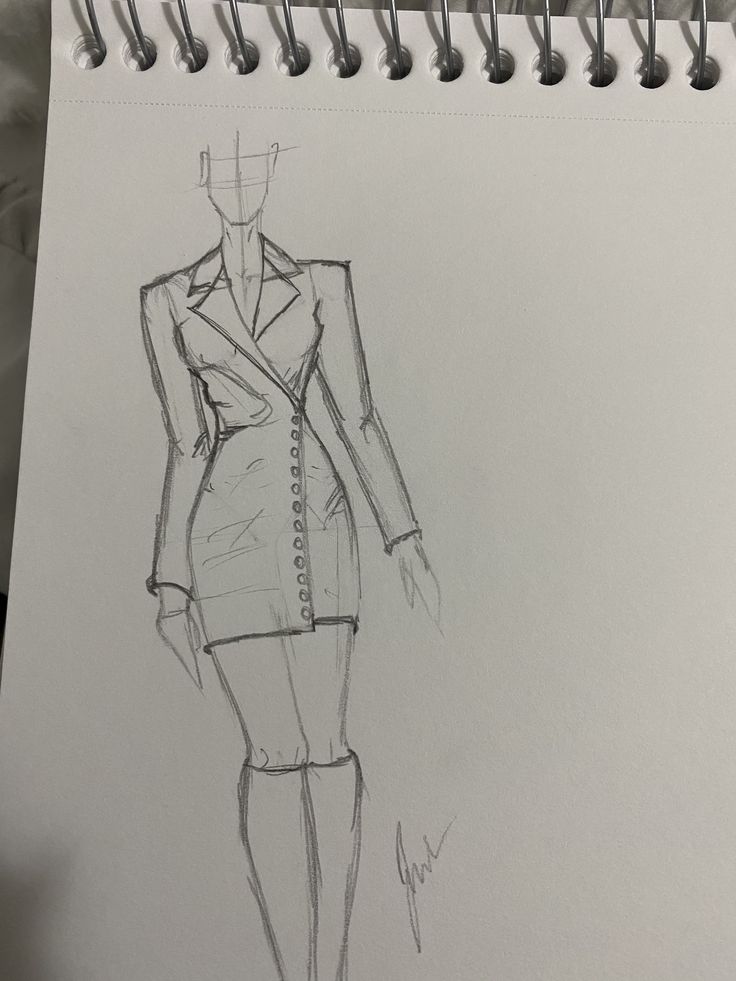 a drawing of a woman's dress and jacket on a notepad next to a pen