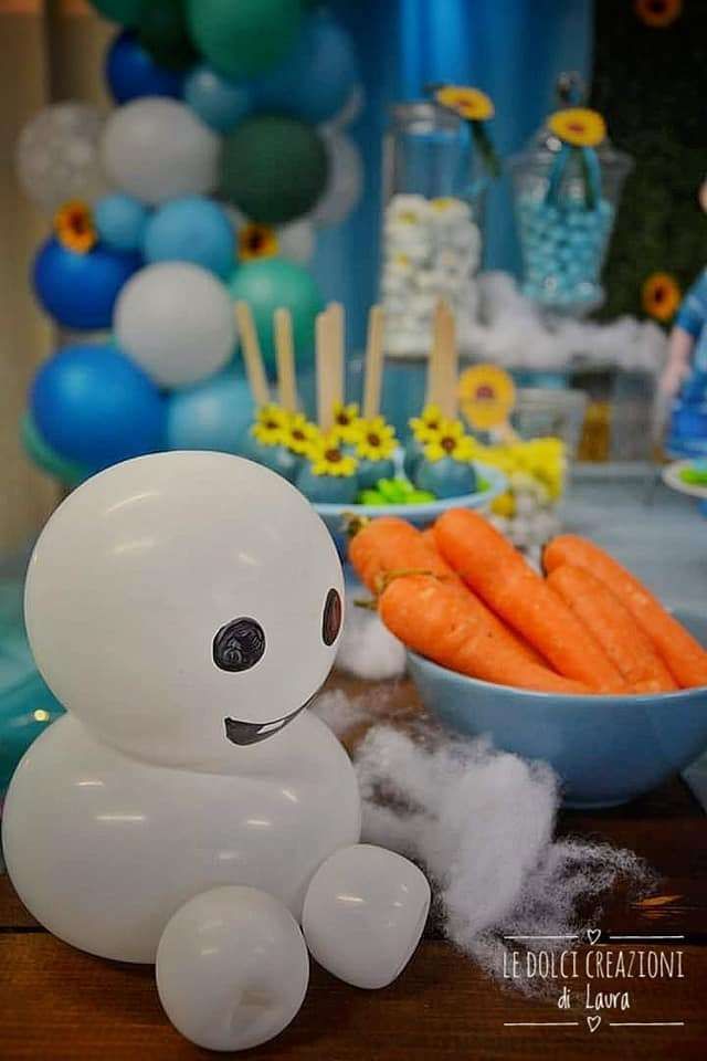 a table with carrots and balloons in the shape of a robot sitting on top of it