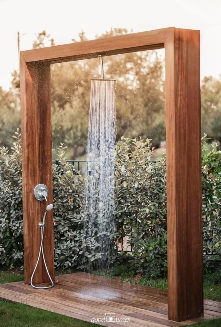 a wooden shower head in the middle of a garden