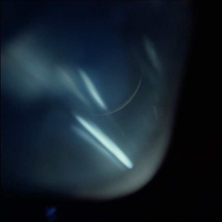 blurry photograph of the back end of an airplane wing at night with light coming from it