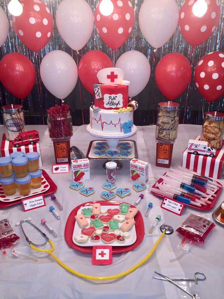 a table topped with lots of desserts and medical themed items on top of it