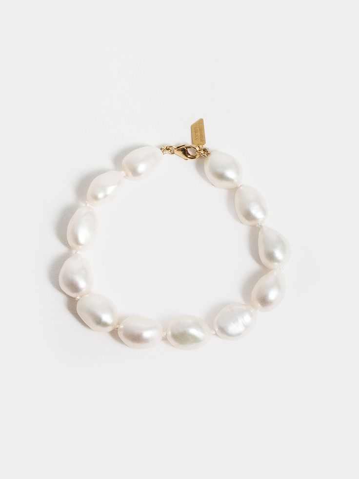 The Capucine Bracelet captures the alluring elegance of baroque pearls, each with its own distinct personality. Created by hand in Los Angeles, this piece is made with a white knotted thread, allowing the organic shapes of the pearls to shine as a centerpiece for any ensemble. Whether layered or worn solo, this pearl bracelet is a luxurious addition to any jewelry collection. 14kt Yellow Gold Baroque Pearl Bracelet Baroque Pearls: 10-13mm x 8-10mm White Knotted Thread Length: 7” Made in L.A. Glo Gold Baroque, Pearl Gemstone, To Shine, Silver Pearls, Baroque Pearls, Organic Shapes, Ring Bracelet, Pearl Bracelet, Gold Vermeil