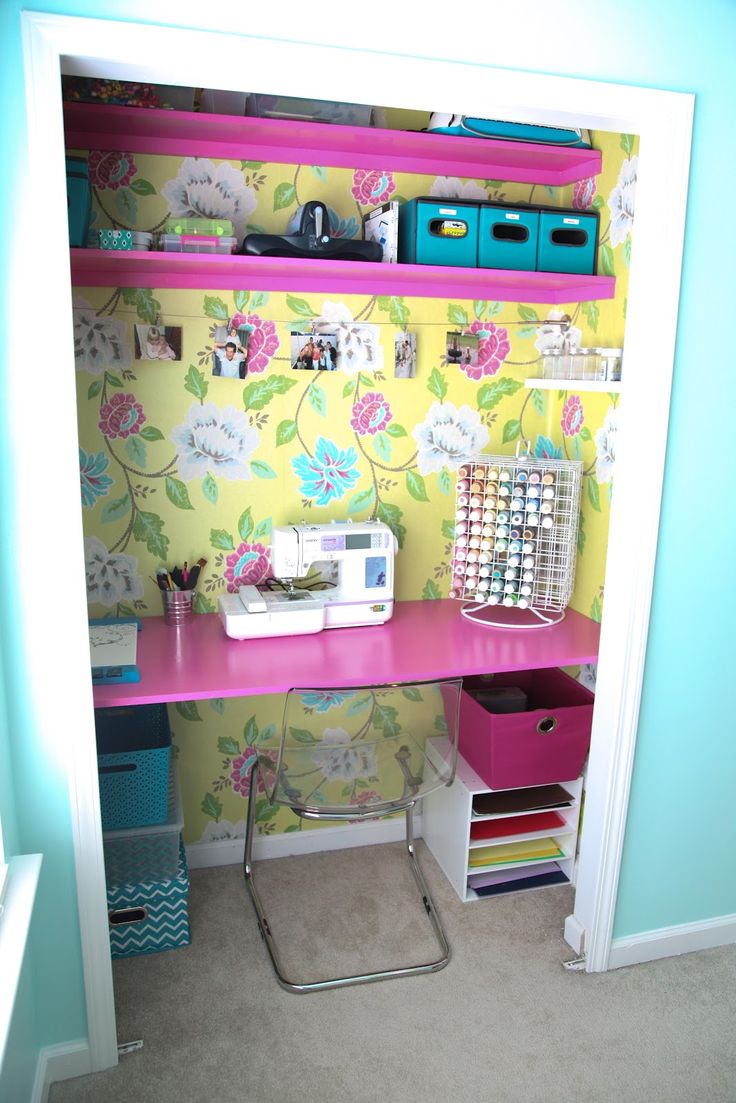 a sewing machine is sitting on top of a pink desk in front of a floral wallpaper