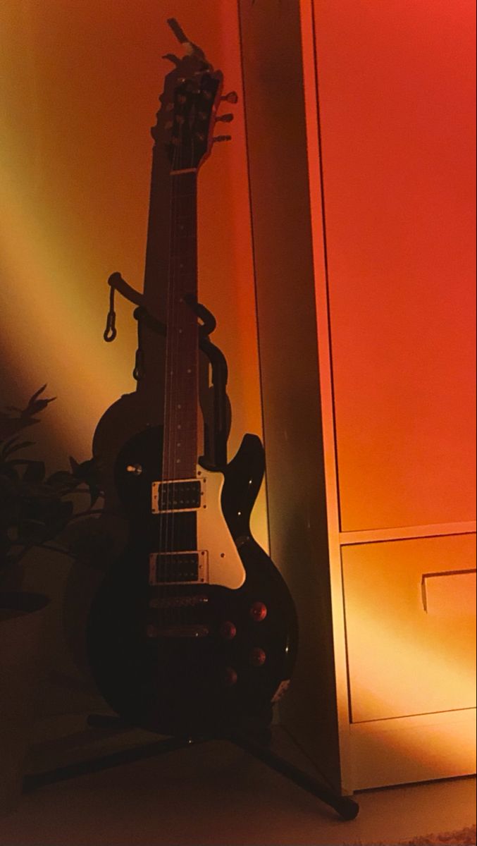 an electric guitar sitting on top of a stand