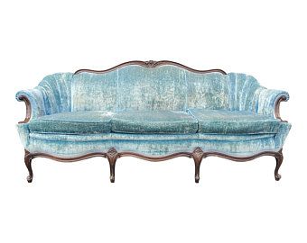 an old fashioned couch with blue velvet upholstered