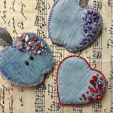 three heart shaped appliques are sitting on top of music sheets