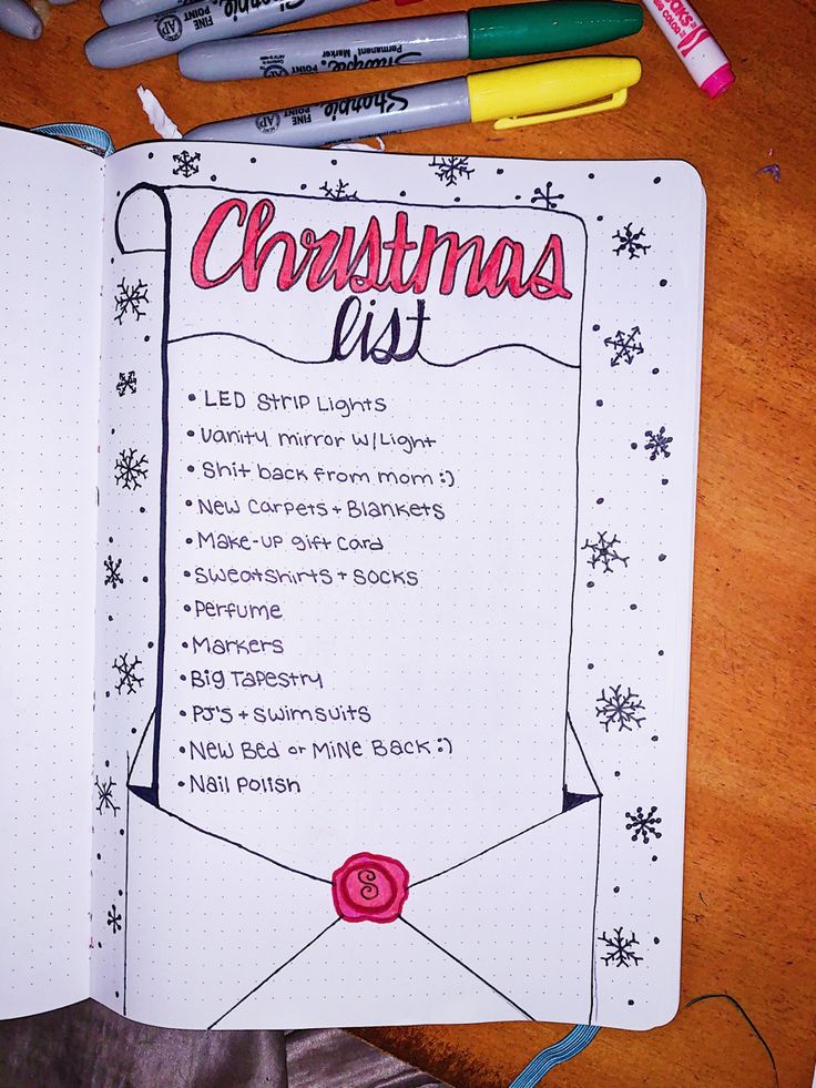 an open christmas list with markers and pens