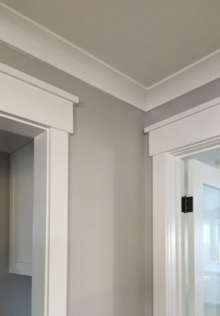 an empty bathroom with white cabinets and gray walls