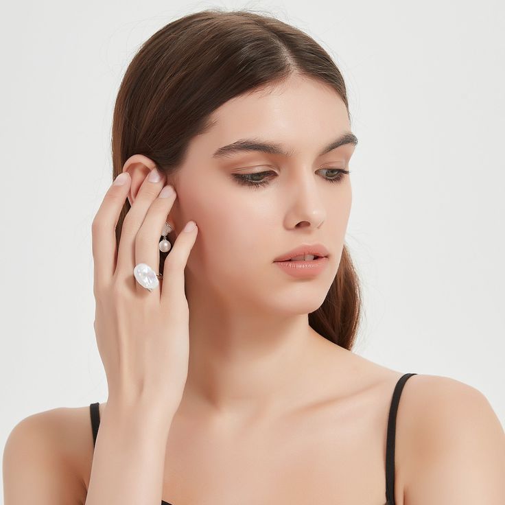 Cessie Ring: Dive into elegance with our Cessie ring, showcasing a striking large baroque freshwater pearl nestled at its heart. Its unique allure is amplified by a gracefully curved arrangement of glistening cubic zirconia, adding just the right touch of sparkle. This masterpiece offers both delicacy and a statement, embodying the perfect balance for modern sophistication Material: 925 Sterling Silver, extra large bold pearl, and cubic zirconia Flexible size with open closure Note: Our jewelry Elegant Diamond Pearl Ring For Promise, Elegant Diamond Pearl Promise Ring, Elegant Pearl Ring With Cubic Zirconia, Elegant Silver Rings With Baroque Pearl, Elegant Pearl White Open Ring, Elegant Pearl White Open Pearl Ring, Elegant Silver Baroque Pearl Rings, Elegant Open Pearl Ring, Elegant Open Diamond Ring For Party