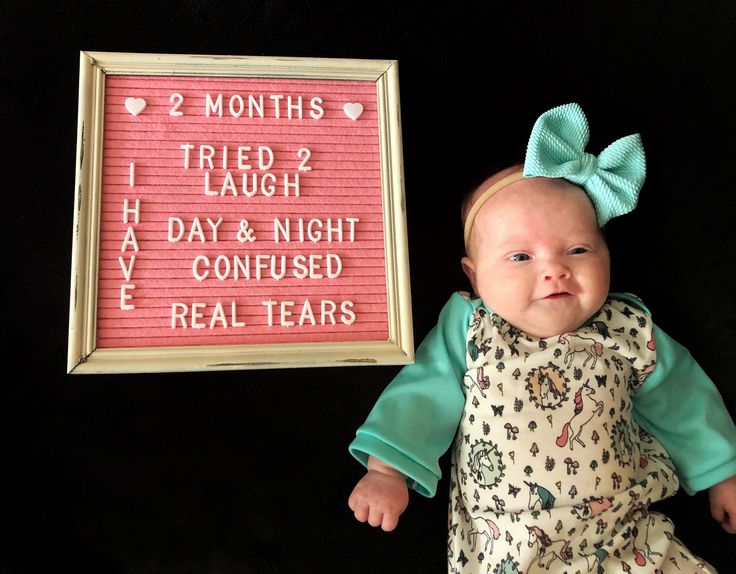 a baby holding up a sign that says 2 months, 1 laugh, 1 day and night have confused real tears