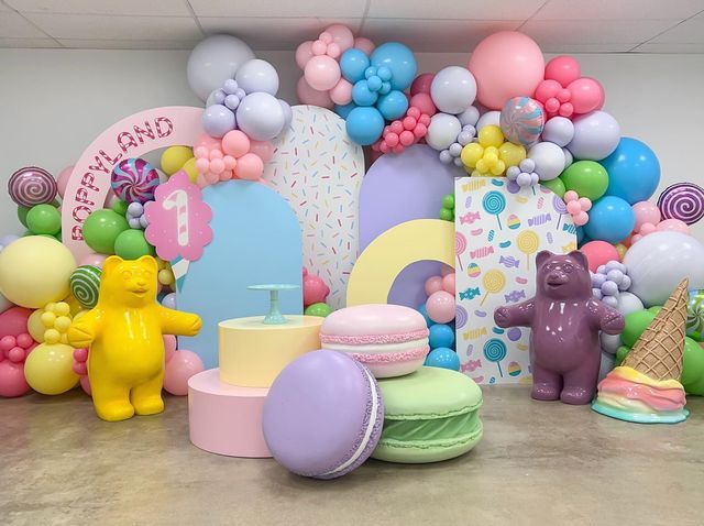 there are many balloons and toys on the floor in this room that is decorated with pastel colors