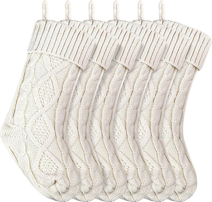 five pairs of white knitted socks hanging from clothes pegs on a line against a white background