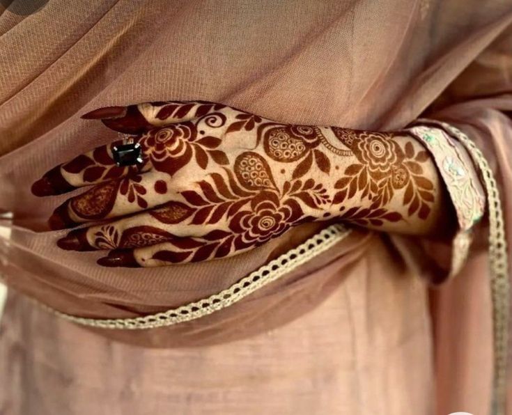 a woman's hand with henna on top of her arm and the wrist