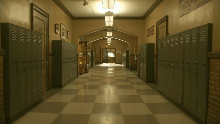 an empty hallway with several lockers on both sides