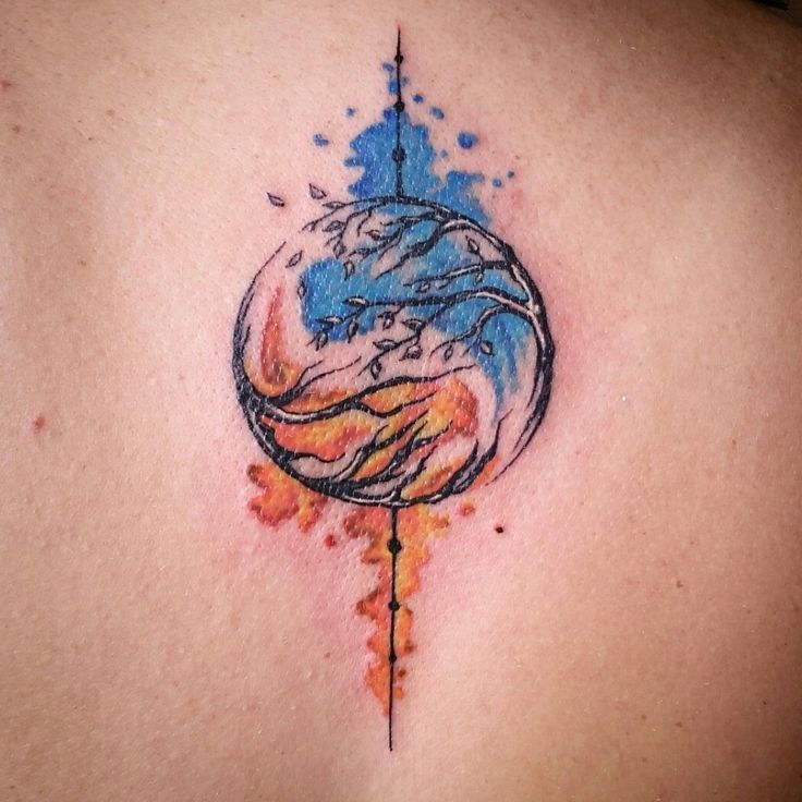 a tattoo on the back of a woman's shoulder with watercolor splashes