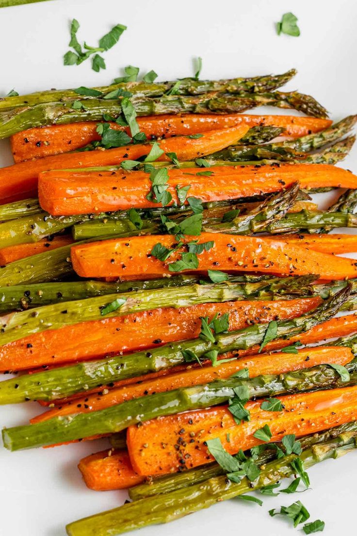 roasted carrots and asparagus on a white plate with parsley garnish