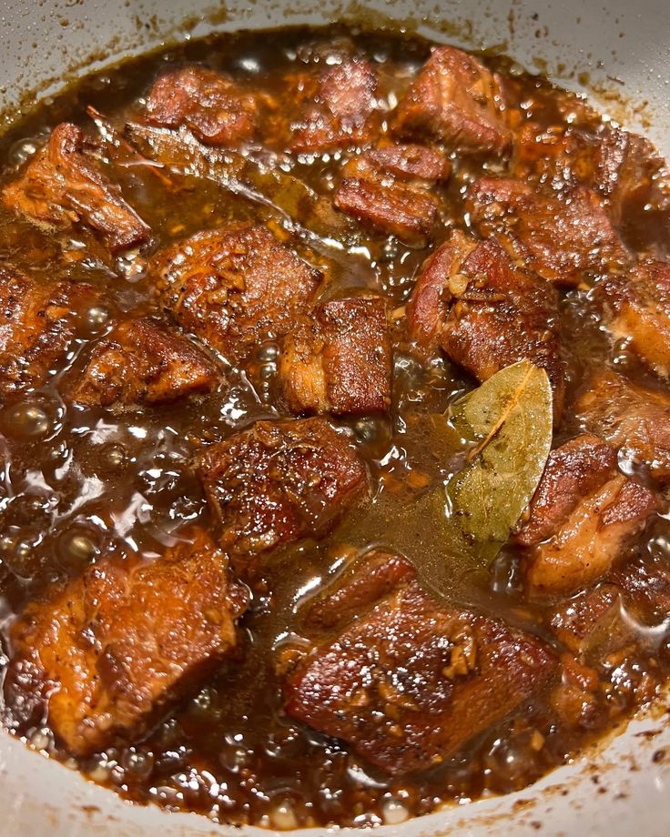 meat and vegetable stew in a white bowl